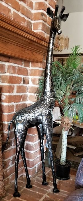 Very tall giraffe sculpture in silver.