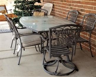Large glass dining patio table and chairs. 2 chairs swivel.