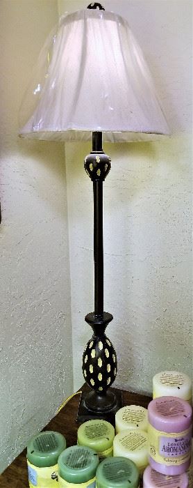 Candlestick black metal lamp with white shade still covered.