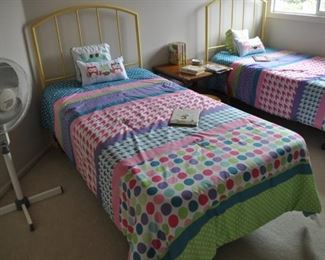 twin beds with high yellow metal headboards on frame (two), wicker chest (26” wide x 14” high x 15” deep)