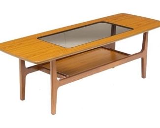 Mid-Century coffee table, tinted glass center pane, two tiers, surfboard style, rising on pin legs.
17.5"h x 54"w x 20"d