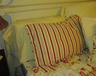 Beautiful bedding on king size white wooden bed.