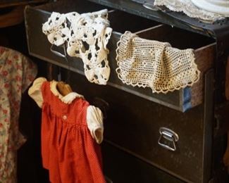 Antique steamer trunk with antique quilt, dress, child's dress, hats, and handkerchiefs