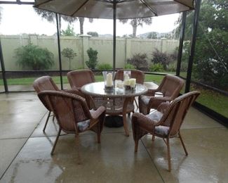 All Weather Wicker Outdoor Dining Set. Natural Color.  Round Table with Glass Top.  6 Dining Chairs with cushions.  Large Umbrella & Stand.  Sold as a set.