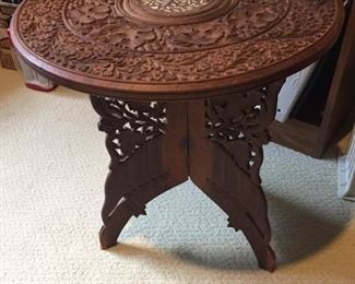Carved table on folding stand.