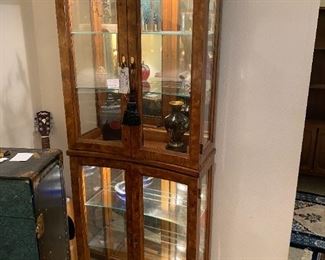 #16	Concave Shaped  display cabinet with 4 doors, 4 glass shelves and burl wood finish  25x11.5x72	 $275.00 
