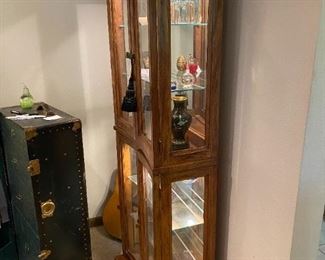 #16	Concave Shaped  display cabinet with 4 doors, 4 glass shelves and burl wood finish  25x11.5x72	 $275.00 
