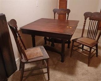 Antique Table with 6 Leaves and 3 Chairs. Located in walkout basement.