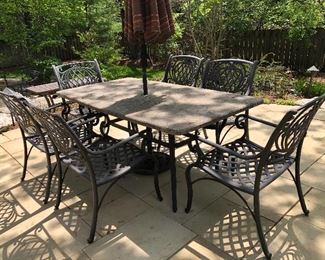 Cast aluminum patio dining chairs and table with faux slate veneer top. California patio umbrella