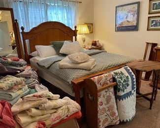 Looking across the Master bedroom, lots of linens, quilt racks, quilts, cushions, accent table