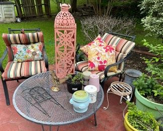 In the back yard we have metals garden chairs with seat pads, outdoor cushions, lantern plant pots