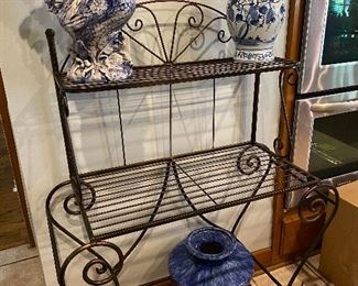 Iron bakers rack and some blue and white decorative items.