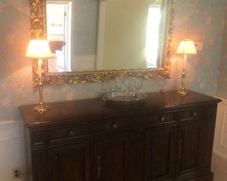 Sideboard with drawers and lower cabinet, buffet lamps and large gold framed mirror