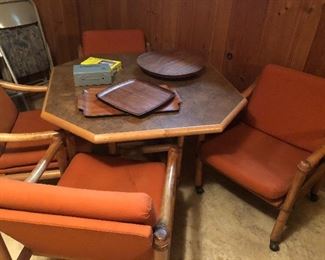 Mid century modern rattan game table with four chairs on casters