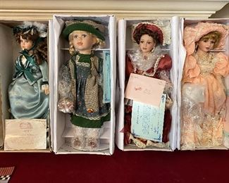 4 large new-in-box porcelain dolls.