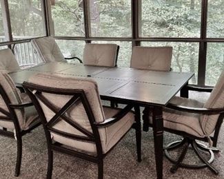 PATIO SET INCLUDES RECTANGLE TABLE WITH HOLE FOR UMBRELLA, FOUR ARM CHAIRS AND TWO SWIVEL CAPTAINS CHAIRS. ALL CHAIRS COME WITH CUSHIONS.