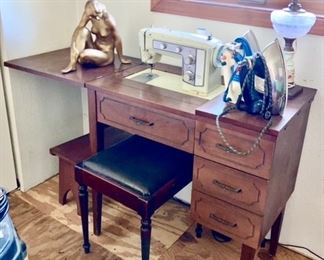 Sewing machine in cabinet w/ stool, nude lady, irons, etc.