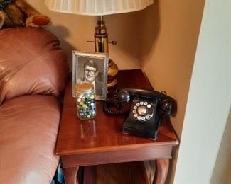 . . . an old rotary phone atop an end table with Queen Anne legs