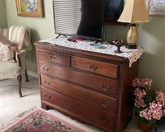 . . . a nice flat-screen TV on beautiful dresser with tasteful area rug in forefront!