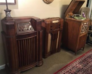 Art Deco Philco short-wave console radio (left). Antique Philco console radio (center).  Antique Emerson console phonograph with discs (right). Also Geib hand-crank phonograph in portable case; produced between 1929 and 1950.