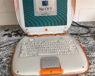 Vintage Apple Mac Clamshell laptop with accessories.