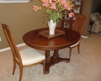 Pedestal dining table and two chairs.