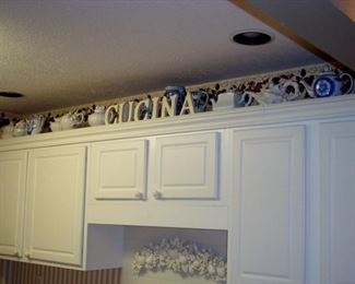 Some teapots above kitchen cupboard.