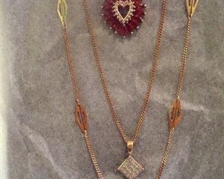 Two short 14 kt. gold chain necklaces at the top. The heart shape pendant necklace described prievous and a 10 kt. gold pendant necklace with a diamond cluster on an 18 kt. gold chain and a long 14 kt. gold chain necklace at the bottom.