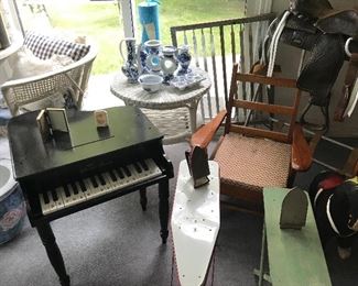 Children's piano, wicker tables, chairs, shelving with blue and white vases, bowls and candle sticks