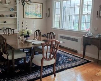 Beautiful Mahogany dining table. Large size. Set of Chippendale style dining chairs. Four sides, two arms.