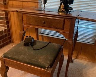 Vintage singer sewing machine in cabinet with matching stool