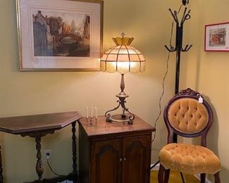 Solid brass base Victorian lamp with a newer slag last aisle shade, carved on a chair and against the wall table