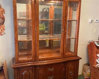 Bassett light cherry finished large China Cabinet with lighting inside the top. Top portion is approximately 48" wide.