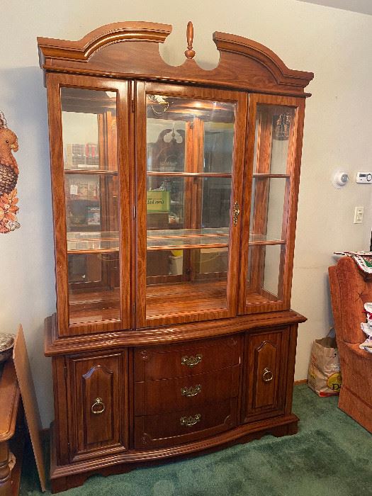 Bassett light cherry finished large China Cabinet with lighting inside the top. Top portion is approximately 48" wide.