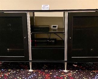 Lot 8010.  $395.00. Very Cool Contemporary Black Media Cabinet  w/ 2 mesh front doors with 3 shelves behind each doo, 2 center shelves and 1 drawer.	66" W x 20" D x 36" T