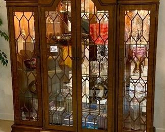 Lot 8024. $1,200.00.  Hooker lighted bookcase/Display/Case with 4 glass doors, 3 glass shelves in each section.  Hooker makes fabulous furniture.  Contents of this cabinet are Not for Sale 	78"W x 84" T x 20" D 