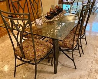 Lot 8041. $1,450.00 Beveled glass top dining table with wrought iron legs and six matching chairs. Our Price is a Steal!  Table: 42" W x 72" L;  chairs  20.5" W x 24" D x 42" T. Our homeowner used this set as the Kitchen Dinette Set.  
