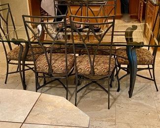 Lot 8041. $1,450.00 Beveled glass top dining table with wrought iron legs and six matching chairs. Our Price is a Steal!  Table: 42" W x 72" L; chairs 20.5" W x 24" D x 42" T. Our homeowner used this set as the Kitchen Dinette Set.  