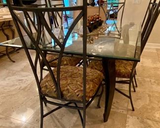 Lot 8041. $1,450.00 Beveled glass top dining table with wrought iron legs and six matching chairs. Our Price is a Steal!  Table: 42" W x 72" L; chairs 20.5" W x 24" D x 42" T.  Our homeowner used this set as the Kitchen Dinette Set.  