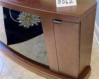 Lot 8062 $575.00 Stunning Corner Media/TV Stand with Premium Wood and Smoked Glass 2 Door Curved Glass Front and 2 Side Storage with Wood Doors.  Glass doors are reflecting the carpet pattern.  	62" W x 22" D x 23" T.   