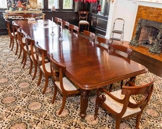 An English Regency style flame mahogany dining suite comprising a table with 4 leaves and 18 chairs.  Table H 28 1/2 x W 169 x D 50 inches.  Chairs H 34 1/2 x W 20 x D 17 inches.  $14,000.00