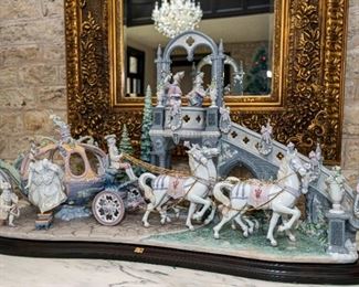A Lladro Porcelain Sculpture. Cinderella’s Arrival. Edition of 1,500. 
This limited-edition Disney princess sculpture depicts Cinderella and her carriage and is decorated with handmade gloss finish porcelain flowers. This substantial piece is one of Lladro's most ambitious projects and marks a milestone for the firm. As described by Lladro, "In a display of artistic and technical virtuosity, even the tiniest detail imagined by Perrault has been recreated: the horses reins are gold-plated while the harnesses are embellished with zircon and the inside of the carriage is profusely decorated."

Condition: Very Good with no chips or fractures noted.
Dimensions: Height 25 ½ x width 44 ½ x depth 16 inches.	                                                                                                   $50,000.00
