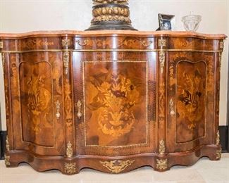 A French Louis Seize Style Commode. Probably First Quarter of the Twentieth Century. No Marks Evident.
The French Louis Seize style commode having a shaped top with pink marble slab over the conforming case with serpentine front having marquetry inlaid floral and foliate decoration overall above the shaped skirt with gilt metal decorative mounts.
Dimensions: Height 43 ¼ x width 73 ½ x depth 17 ½ inches.    $7,000.00
