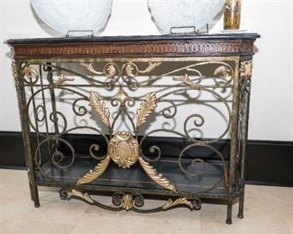 A French Style Marble and Wrought Iron Side Table. Circa 2005-2010. No Marks Evident. 

The table of wrought iron composition, the shaped top with conforming black marble slab, the frame with scroll and gold painted acanthus leaf decoration.

Condition: Very Good.
Dimensions: Height 36 x width 48 x depth 18 inches.  $1,500.00
