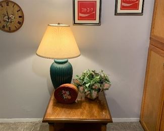 Cross stitch pictures of Coca-Cola logo in American and Japanese, Wood end table, green lamp, handpainted shaker box, and large assortment of artificial plants
