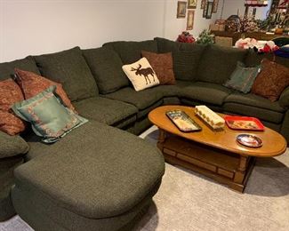 Very comfortable green sectional sofa, coffee table, selection of Coca-Cola trays