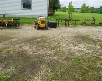 Cub Cadet nonworking mower, no key, and small farm field equipment including Lister rower and bottom plow