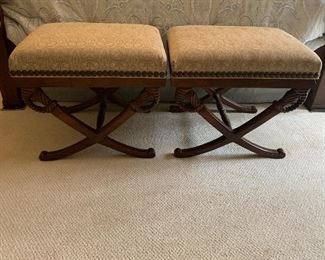 A pair mahogany benches with nail head trim around the upholstery