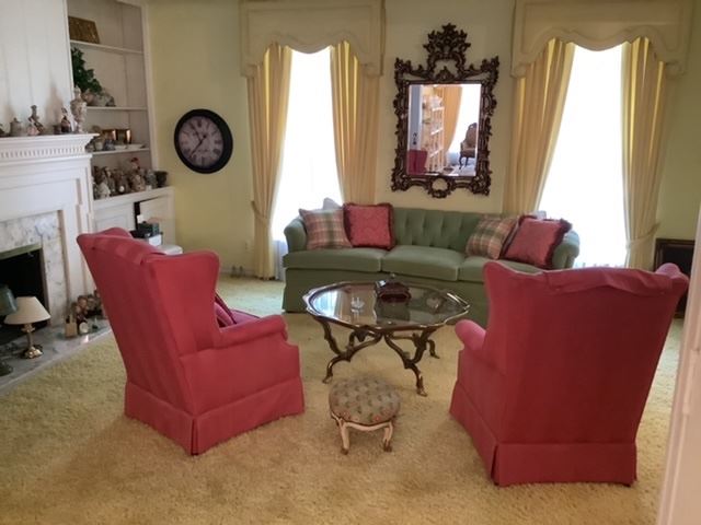 Vintage brass and glass coffee table, two upholstered chairs, green button tufted couch, goldleaf fancy mirror