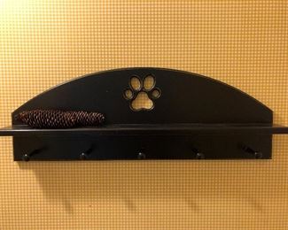 Walk-mounted coat rack with dog paw cutout.